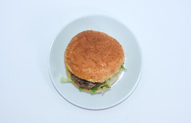 hamburger double patty with lettuce and tomato on plate from top view