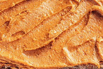 Close-up of peanut butter spread. Abstract food background. Top view.