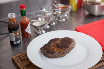 Close up of a delicious juicy ribeye steak on the plate at restaurant kitchen