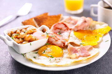 english breakfast with fried egg, bacon and bean