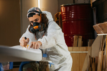 Male with surform tool for shaping surfboard