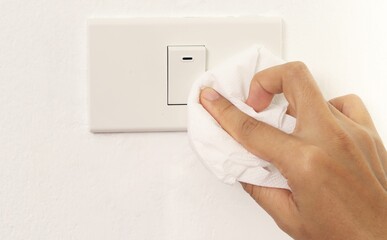 Lady cleaning the light switch in the house