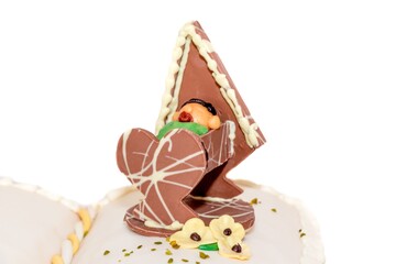Marzipan baby sleeping in chocolate cradle on sweet baptism cake. Infant sleeps in bed after birth. Manual work from confectioner. Wonderful present for birthday celebration or christening ceremony