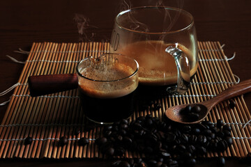 Strong hot coffee with beans on dark background