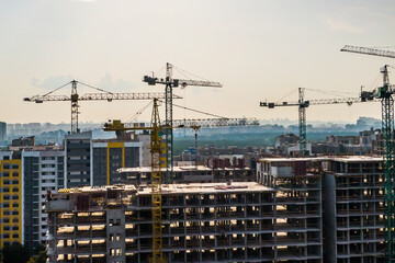 building cranes working and sunset sky. housing estate development. general view.