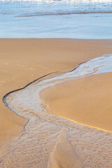 water running into the sea on the beach sand