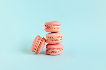 Tasty french pink macarons on a blue pastel background.
