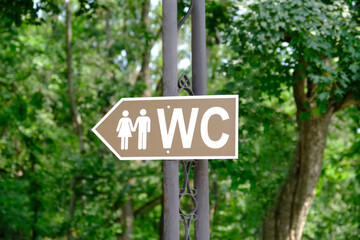 Toilet sign in the park. Toilet sign for women and men. How to get to the toilet. Selective focus