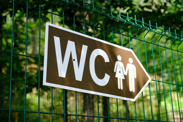 Toilet sign in the park. Toilet sign for women and men. How to get to the toilet Selective focus.