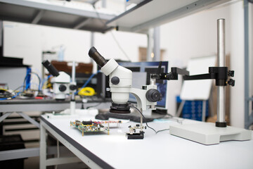 Microscope and electronic board in Scientific research tech Laboratory on table.