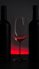 .Conceptual photo of wine bottle and glass on red background.