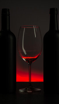 .Conceptual photo of wine bottle and glass on red background.