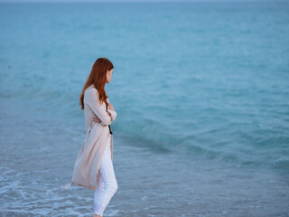 woman walks along the shore ocean landscape vacation evening romance