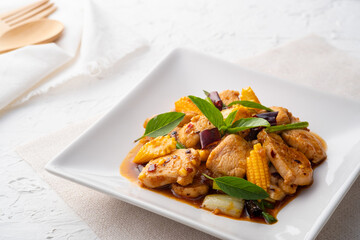 Stir fry chicken and chili paste in oil on white plate (Gai Pad Nam Prik Pao)