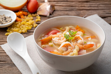 Macaroni Soup with Shrimps ,tomato ,carrots and onion on white bowl