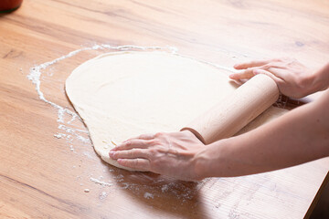 Fototapeta premium Woman rolled dough with rolling pin