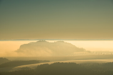 gelbes Licht über einer Landschaft im Nebel
