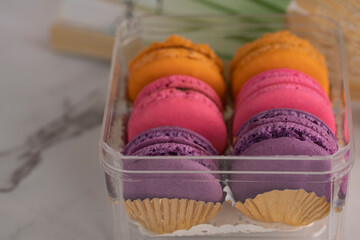 Close-up of delicious macaroon, a famous French dessert in a container. Selective focus. Blurred background