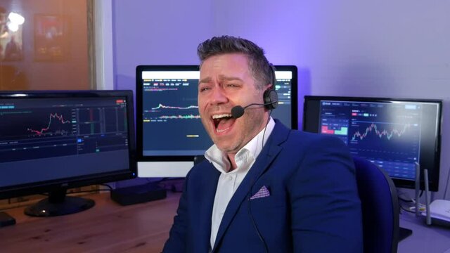 Funny forex cryptocurrency trader analyst broker scammer laughing intensely as he runs a crypto scam. The businessman has a smug look and he laughs loudly.