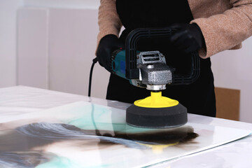 A grinding machine in the hands of a young woman artist.