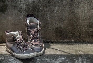 Brown Retro High Top Canvas Sneakers was placed on old cement floor. Vintage age-worn sneakers...