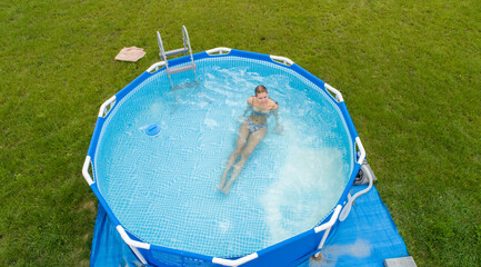 A shapely slim blonde in the garden pool. Photo from the drone
