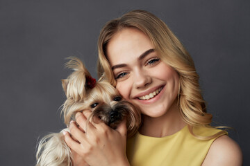 cheerful blonde in a yellow dress little purebred dog fun