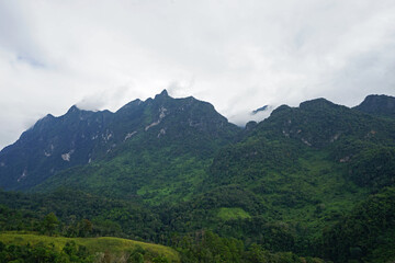 Natural landscape of green mountain range with cloudy blue sky