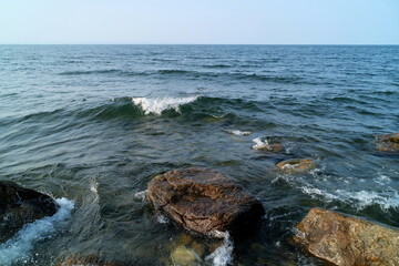 Surf waves go to the eastern shore of Lake Baikal in shallow water zone with a rocky bottom. Buryatia. Russia