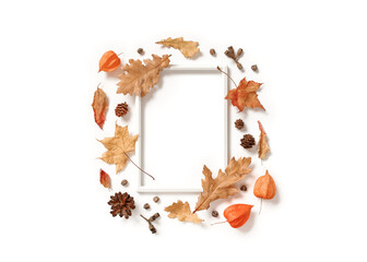 An empty photo frame, physalis flowers, dried maple and oak leaves, cones and seeds are on a white background. Autumn, fall, thanksgiving day concept. Flat lay. Top view. Copy space.