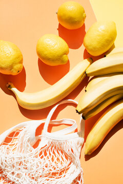 Overhead view of bananas, lemons and mesh bag