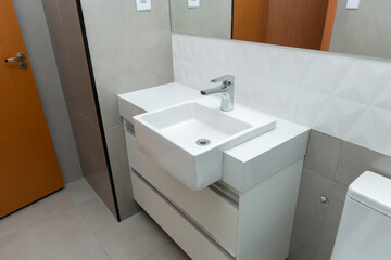 White marble sink with modern overlay basin and shiny stainless steel faucet