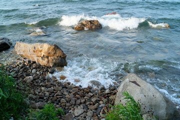 Waves pass between stones near the eastern shore of Lake Baikal in the Russian Buryatia