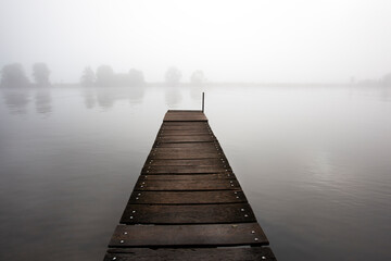 Jetty in the misty river Meuse in Geijsteren in North Limburg