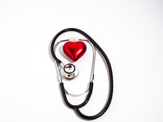 Red heart and stethoscope on a white table.