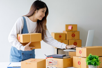 Portrait of Starting small businesses SME owners female entrepreneurs working on receipt box and check online orders to prepare to pack the boxes, sell to customers, sme business ideas online.