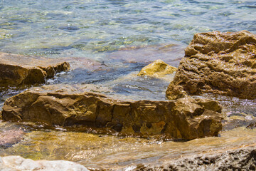 Fototapeta na wymiar Big stone close-up on the background of the sea. Group of large stones. Boulders are standing in the beautiful water. Rocky seaside coast.