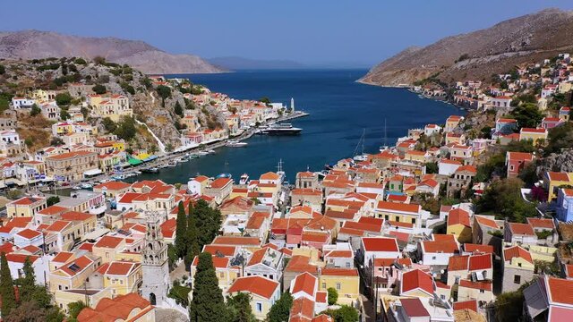 View on Symi (Simi) island harbor port, classical ship yachts, houses on island hills, Aegean Sea bay. Greece islands holidays vacation travel tours from Rhodos island. Symi, Greece,  Dodecanese.