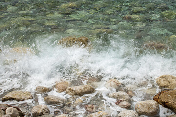 Group of large gray stones. Boulders are standing in the beautiful water. Rocky seaside coast. Wallpaper - sea and rocks met.