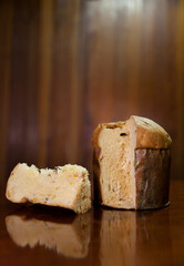 Panettone slice on the table. Panettone cut on wooden table and textured background. Panettone concept. Chocotone concept.
