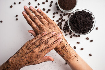 Young woman hand applying coffee grounds scrub massaging cosmetic skincare. Scrub exfoliates old...