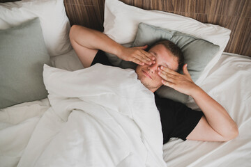 man waking up in the morning, stretching the body and open eyes