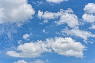 Beautiful cumulus clouds against the blue daytime sky.