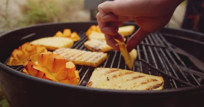 Fresh mango, pineapple slices and a wheel of brie cheese in a ramekin being placed on a barbecue grill