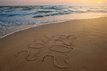 Sea wave rolling onto sandy beach with written 2022 and 2023. New Year