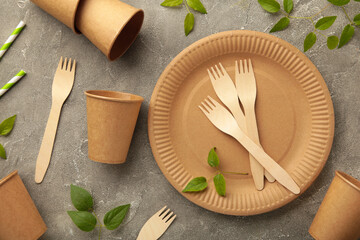 Eco friendly disposable dishes with green leaves on grey background. Zero waste, eco friendly,...
