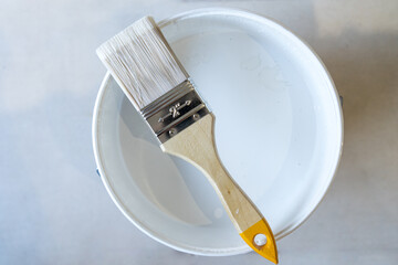 Isolated bristle brush with white paint pot - obrazy, fototapety, plakaty