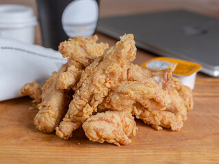 Chicken nuggets fried in breadcrumbs lie on a serving board