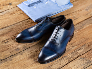 Classic men's shoes made of blue leather on a background of a surface from old boards