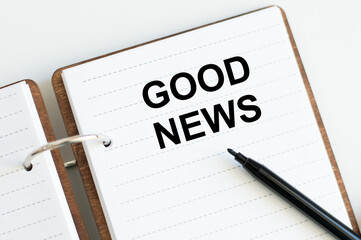 Text GOOD NEWS on a notebook on a white background - business, banking, finance and investment concept.